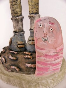 detail of the base of piece.  This is one of the three wooden earthworms that are coming out from the cement ground that the main character is standing upon.  