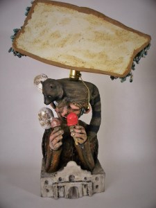 this shows a figure who is suppose to resemble davy crockett although there are no photos of him. wearing a raccoon hat--both him and the raccoon are eating icecream.  they are both on top of the Alamo.  The shade is in the shape of Tennessee adorned with individually made blue drops---resembling, sweat, tears, and the mississippi river which I imagine him having to have taken river transportation to get here---but still not sure.  